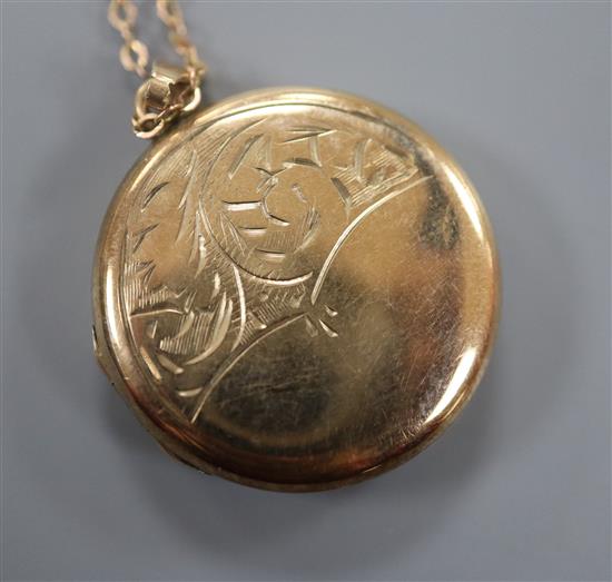 A yellow metal locket with engraved front, on a 9ct fine link chain, locket 21mm.